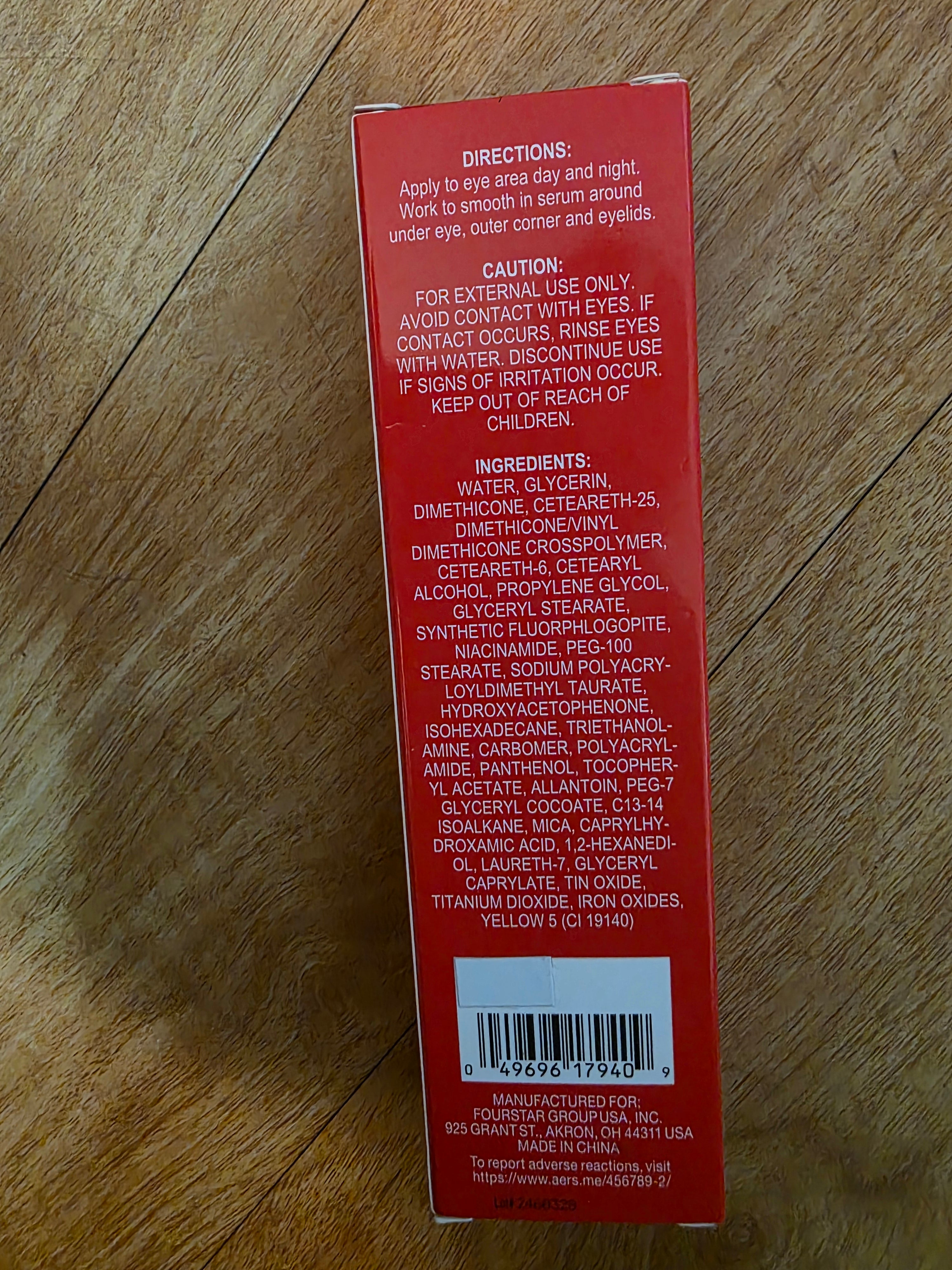 Red product box with text and a barcode on a wooden surface