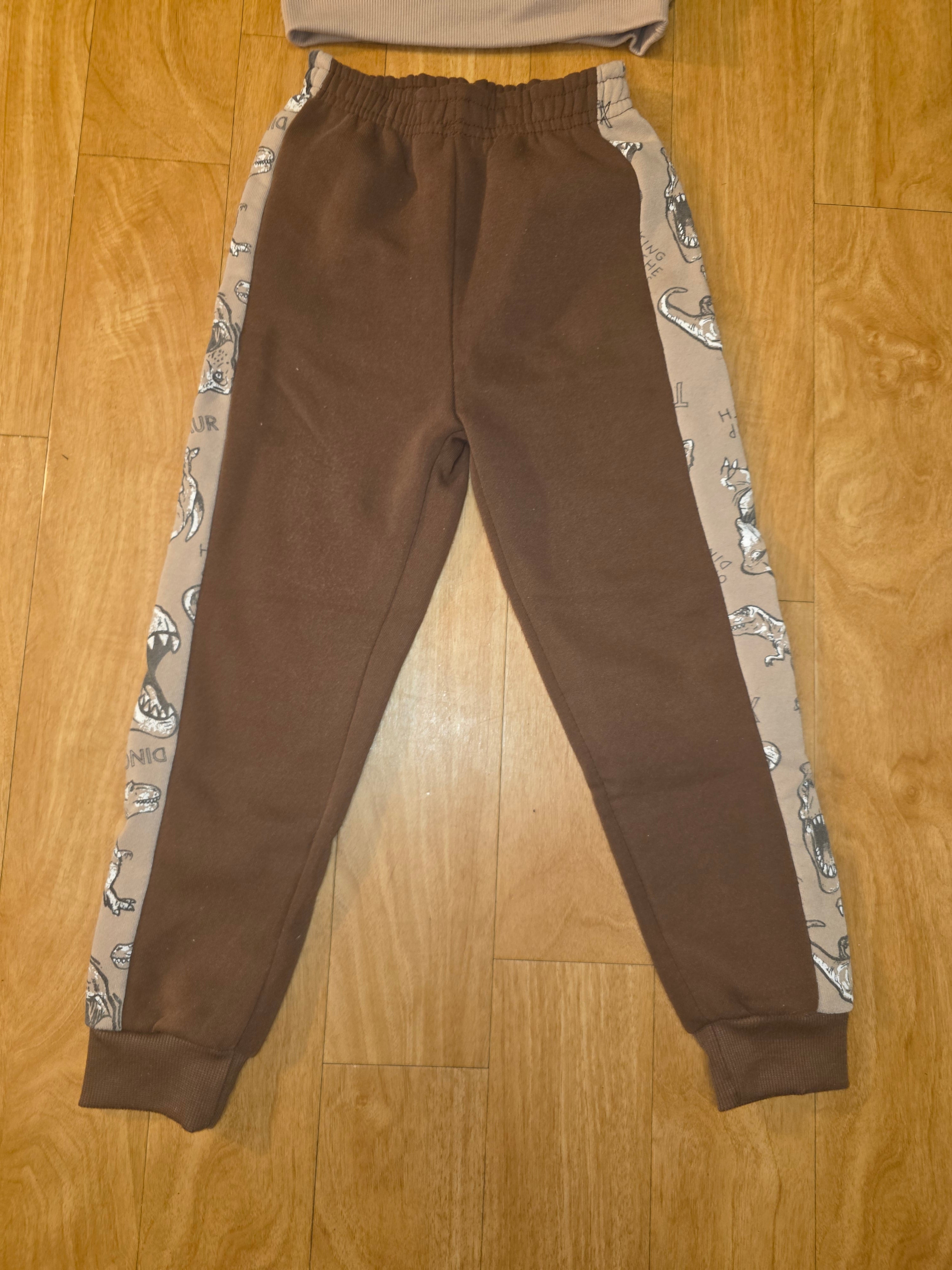 Brown pants with patterned lining on a wooden floor