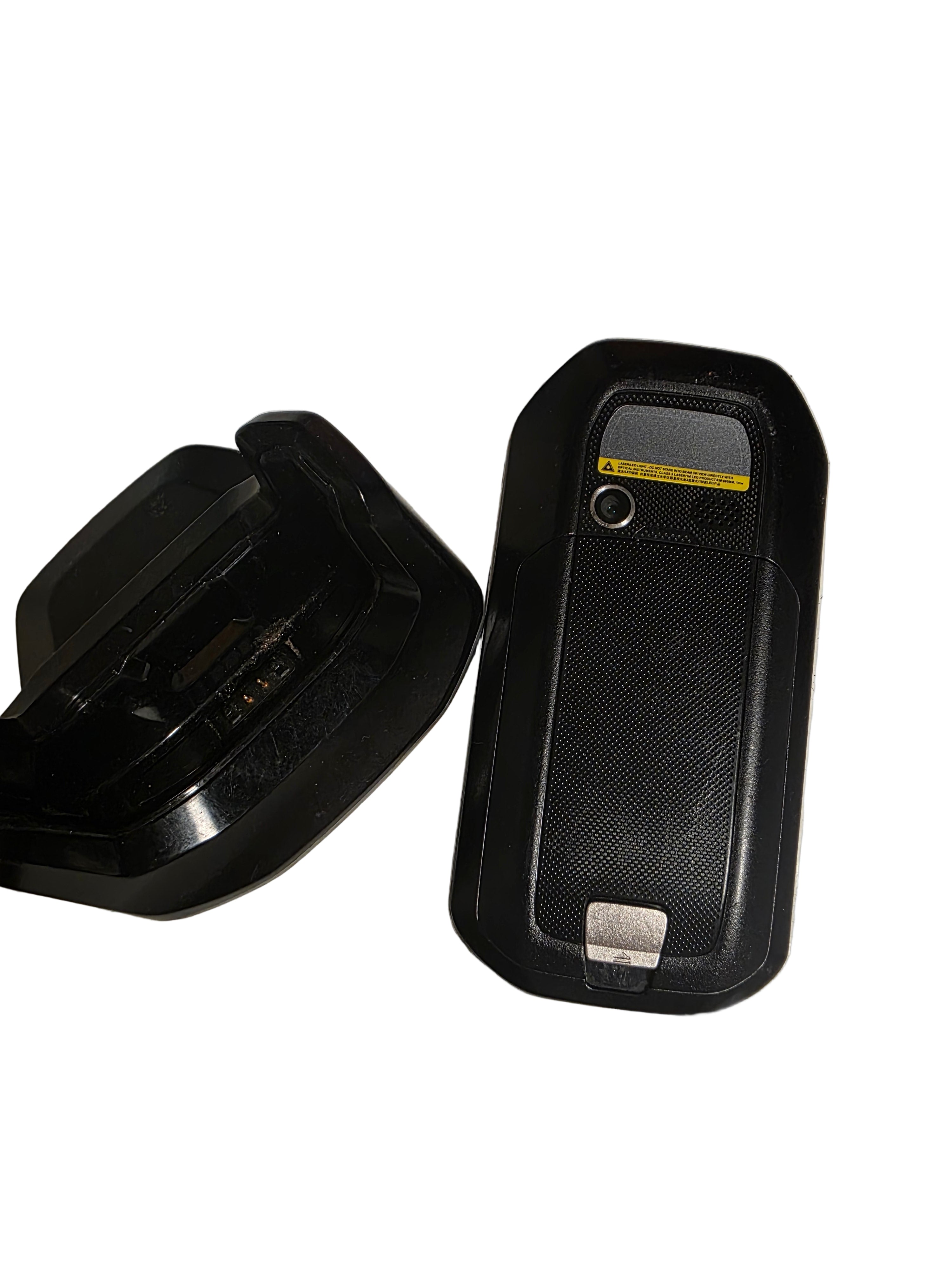 Two black plastic components on a textured metal surface