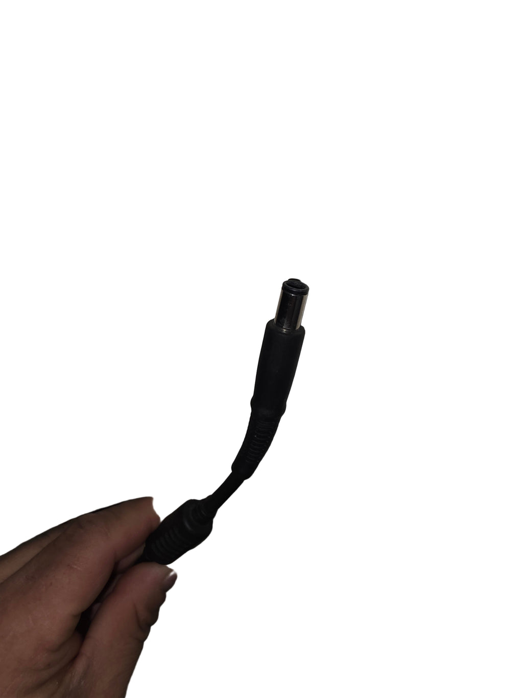 Black electrical cable with plug held against a white wall